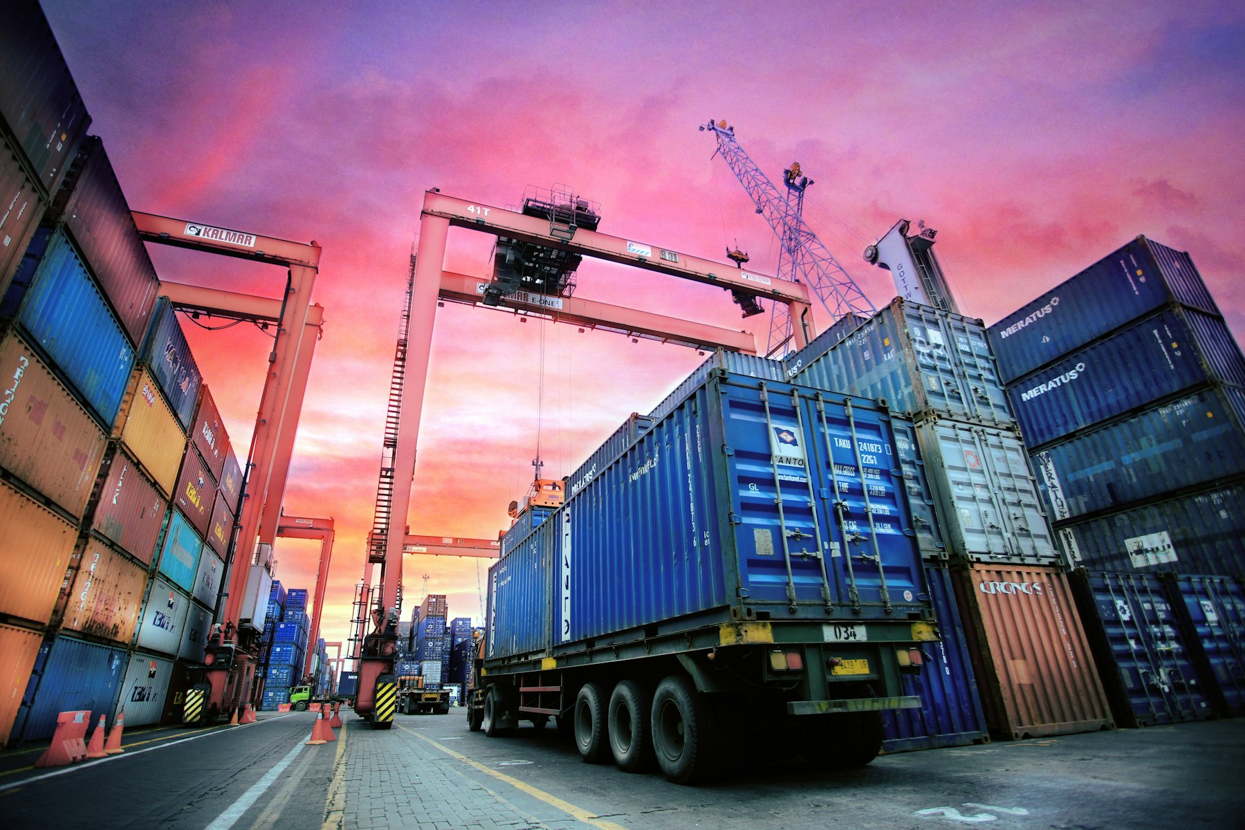 Cargo containers and freight truck at a port at dusk